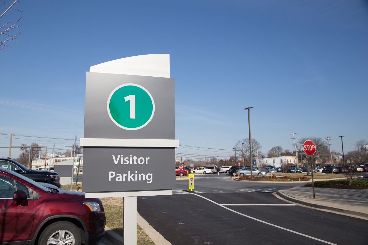 Our public parking lot #1/Green is marked with a dark gray post-mounted sign showing a number 1, within a green circle, and the text 